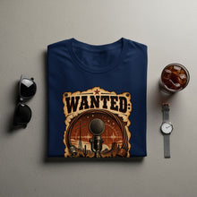 Load image into Gallery viewer, Dark blue t-shirt with a "Wanted" design featuring a microphone and a desert landscape.
