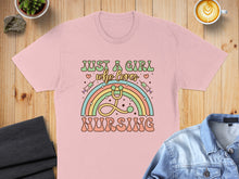 Load image into Gallery viewer, Pink t-shirt with rainbow, stethoscope, and text "Just a girl who loves nursing".
