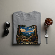 Load image into Gallery viewer, T-shirt graphic of person with ham radio in mountain landscape at sunset.
