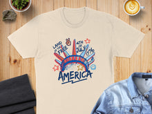 Load image into Gallery viewer, Cream t-shirt with "Land of the Free 4th of July America" graphic.
