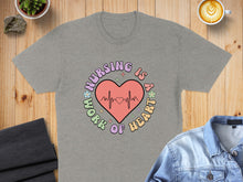 Load image into Gallery viewer, Grey t-shirt with "Nursing is a work of heart" text and EKG line.
