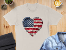 Load image into Gallery viewer, Cream t-shirt with frayed American flag heart graphic, displayed with denim jacket and coffee.
