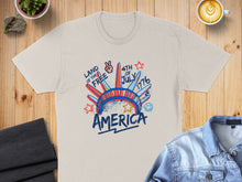 Load image into Gallery viewer, Cream t-shirt with "Land of the Free 4th of July America" graphic.
