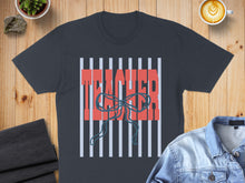 Load image into Gallery viewer, Dark gray t-shirt with "TEACHER" in red text over blue stripes and a bow.
