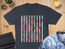 Load image into Gallery viewer, Dark grey t-shirt with "Last Day of School" text and red ribbon graphic.
