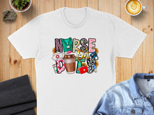 Load image into Gallery viewer, White t-shirt with "NURSE" in colorful block letters and medical icons.
