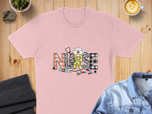 Load image into Gallery viewer, Pink t-shirt with "NURSE" text, stethoscope, pills, and spiders.
