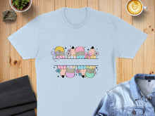 Load image into Gallery viewer, Light blue t-shirt with colorful pencil tips and bows graphic design.
