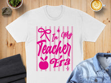 Load image into Gallery viewer, White t-shirt with pink text "In My Teacher Era" and bow design.

