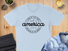 Load image into Gallery viewer, Light blue t-shirt with "Land of the Free Since 1776 Because of the Brave" graphic.
