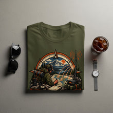 Load image into Gallery viewer, Olive green t-shirt with a graphic depicting a person planning a route on a map.
