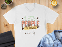 Load image into Gallery viewer, White t-shirt with "I stab people for a living" text and nurse life hashtag.
