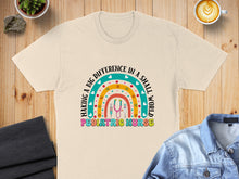 Load image into Gallery viewer, Cream t-shirt with rainbow graphic and "Pediatric Nurse" text.
