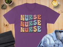 Load image into Gallery viewer, Purple t-shirt with "NURSE" repeated in colorful, retro font.
