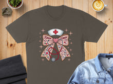 Load image into Gallery viewer, Brown t-shirt with a pink bow, stethoscope, and nurse cap graphic.
