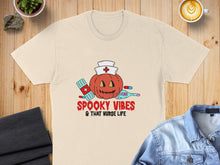 Load image into Gallery viewer, Cream t-shirt with "Spooky Vibes &amp; That Nurse Life" text and Halloween-themed nurse illustration.
