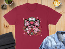 Load image into Gallery viewer, Red t-shirt with pink bow graphic featuring stethoscope, heart, and "XOXO" text.
