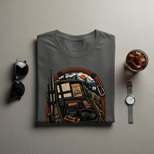 Load image into Gallery viewer, T-shirt with illustration of a backpack, radio equipment, and mountain landscape.
