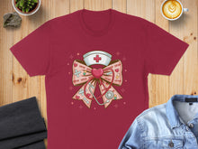 Load image into Gallery viewer, T-shirt with nurse's cap, stethoscope, hearts, and "XOXO" text on a bow.
