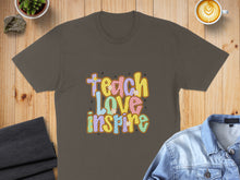 Load image into Gallery viewer, T-shirt with "Teach Love Inspire" text in colorful retro font and floral accents.
