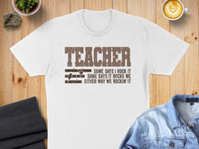 Load image into Gallery viewer, White t-shirt with "TEACHER SOME DAYS I ROCK IT SOME DAYS IT ROCKS ME EITHER WAY WE ROCKIN' IT" text.

