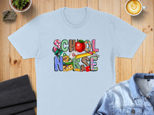 Load image into Gallery viewer, Light blue t-shirt with "School Nurse" text featuring school supply graphics.
