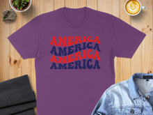 Load image into Gallery viewer, Purple t-shirt with "America" repeated in red and blue text.
