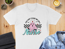 Load image into Gallery viewer, White t-shirt with a ghost in a nurse hat saying "You can't scare me I'm a nurse".
