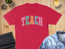 Load image into Gallery viewer, Red t-shirt with "TEACH" in colorful block letters, flat lay.
