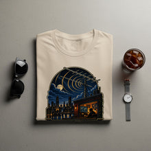 Load image into Gallery viewer, T-shirt with a graphic of a city skyline at night, a radio tower, and a person in a control room.
