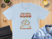 Load image into Gallery viewer, Light blue t-shirt with "Some nurses cuss too much" and medical icons.
