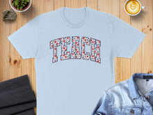 Load image into Gallery viewer, Light blue t-shirt with "TEACH" printed in floral pattern.
