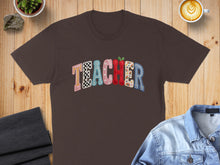 Load image into Gallery viewer, Brown t-shirt with colorful checkered "TEACHER" text and small apple accent.
