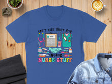 Load image into Gallery viewer, Royal blue t-shirt with "Can't talk right now, doing nurse stuff" and medical icons.
