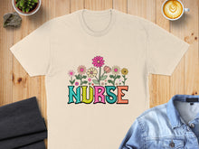 Load image into Gallery viewer, Beige t-shirt with colorful floral "NURSE" text design.
