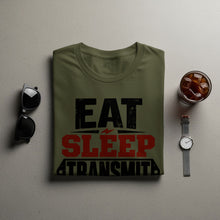 Load image into Gallery viewer, Olive green t-shirt with "EAT SLEEP TRANSMIT" text, sunglasses, and iced drink.

