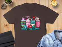 Load image into Gallery viewer, Brown t-shirt with cartoon coffee cups and medical items for nurse practitioners.
