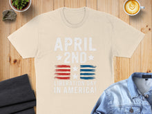 Load image into Gallery viewer, Cream t-shirt with "APRIL 2ND LIBERATION DAY IN AMERICA!" and flag design.
