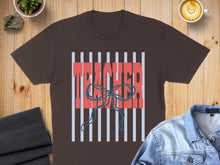 Load image into Gallery viewer, Brown t-shirt with "TEACHER" in red text over blue stripes and a bow.

