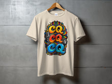 Load image into Gallery viewer, Tan t-shirt with "CQ CQ CQ" in colorful graffiti style, microphone, and radio.
