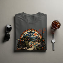 Load image into Gallery viewer, T-shirt graphic: explorer with map, compass, radio, and mountains.
