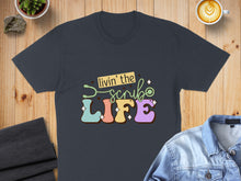 Load image into Gallery viewer, Dark t-shirt with "Livin' the Scrub Life" text and stethoscope graphic.
