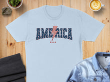 Load image into Gallery viewer, Light blue t-shirt with "America" text and lightning bolt design.
