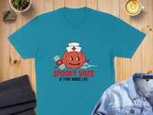 Load image into Gallery viewer, Teal t-shirt with spooky pumpkin, bandages, and thermometer graphic.

