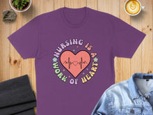 Load image into Gallery viewer, Purple t-shirt with "Nursing is a work of heart" and a heartbeat graphic.
