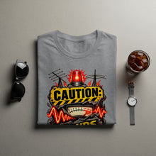 Load image into Gallery viewer, Grey t-shirt with a "CAUTION:" graphic featuring a siren and vintage meter.
