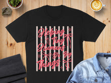 Load image into Gallery viewer, Black t-shirt with pink text that reads "Helping Tiny Humans Do Big Things".
