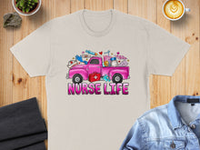 Load image into Gallery viewer, Pink truck graphic with nurse-themed items and "Nurse Life" text on a beige t-shirt.
