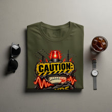 Load image into Gallery viewer, Olive green t-shirt with "CAUTION" sign graphic featuring a siren and analog meter.
