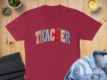 Load image into Gallery viewer, Maroon t-shirt with colorful "TEACHER" text and apple graphic.
